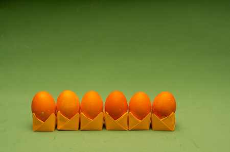 Bright composition of painted easter eggs on origami stands in a rowの写真素材