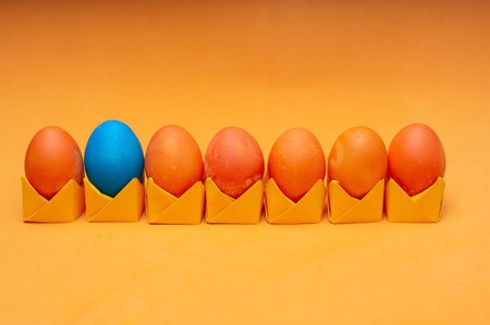 Colored painted easter eggs on origami stands in a row