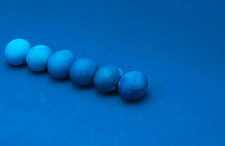Easter eggs layout on blue background. ombre effect. classic blue monochromatic compositionの写真素材
