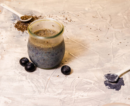 Homemade blueberry chia pudding decorated with fresh berries on concrete background. Healthy food, blue matcha powderの写真素材