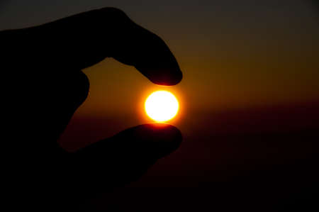 hand holding the sunの写真素材