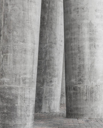 Detail of a row of white concrete pillars with paving slabs
