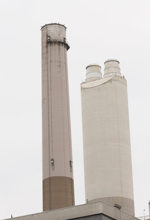 Two smokestacks of a power plant on a cloudy day
