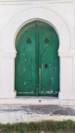 Traditional old painted door in a historical district or medina, Tunisia. Colorful textured image of muslim architecture.の写真素材