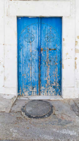 Traditional old painted door in a historical district or medina, Tunisia. Colorful textured image of muslim architecture.の写真素材