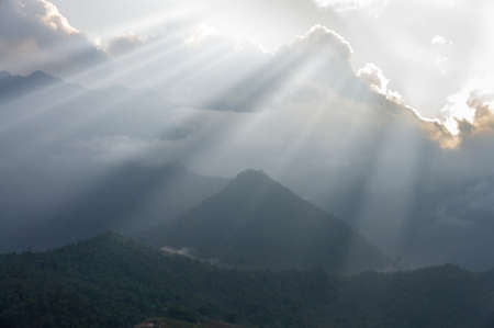 rays of the sun from behind the clouds over the mountains. North Vietnam.の写真素材
