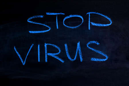 The inscription "stop virus" on a black board. Blue chalkの写真素材
