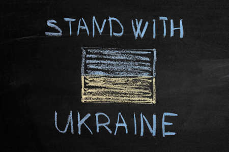 inscription stand with Ukraine on a black board with chalk. ukraine flag drawn with chalk.の写真素材
