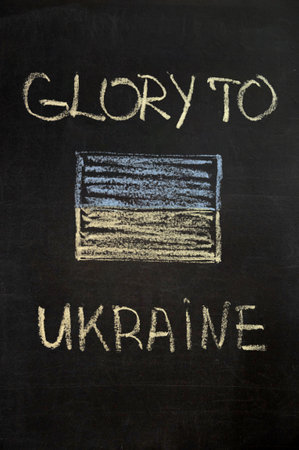 inscription glory to Ukraine on a black board with chalk. ukraine flag drawn with chalk. verticalの写真素材