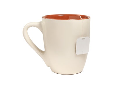 Beige ceramic mug with teabag label. isolated on white backgroundの写真素材