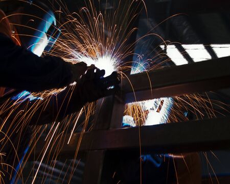 Two metal workers Mig welding some steel sections.の写真素材