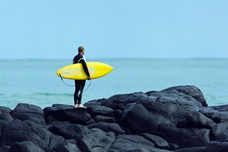 Guy standing on the waves waiting to go surfing.の写真素材