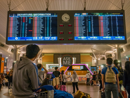 Male Passenger Looking at Flight Timetable in Airportのeditorial素材
