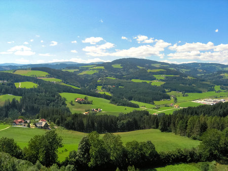 Austrian landscape with vivid cloudy sky and cottage houses down in the valleyの写真素材