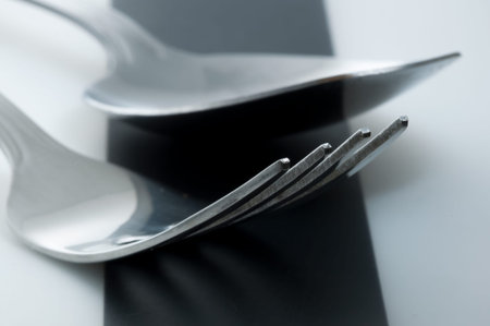 Fork and spoon laying next to each other on striped black and white