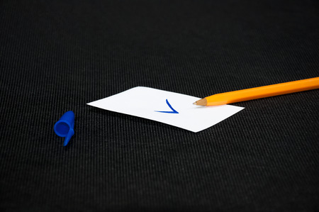 A blank sheets of paper next to a pen on a dark background. Layout for design. Top view, place for text.の写真素材