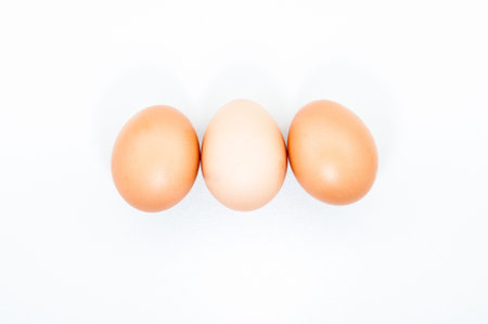 Three eggs in a row isolated on white blank background