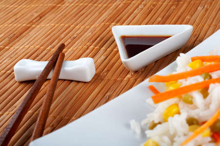 Salad of rice with sauce and sticks on bamboo matの写真素材
