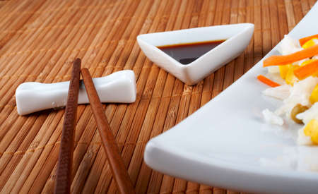 Salad of rice with sauce and sticks on bamboo matの写真素材
