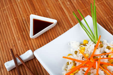 Salad of rice with sauce and sticks on bamboo matの写真素材