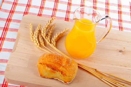 Orange juice and bread on wood matの写真素材
