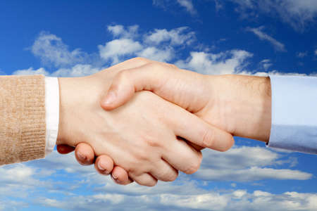 Business handshake over a sky backgroundの写真素材
