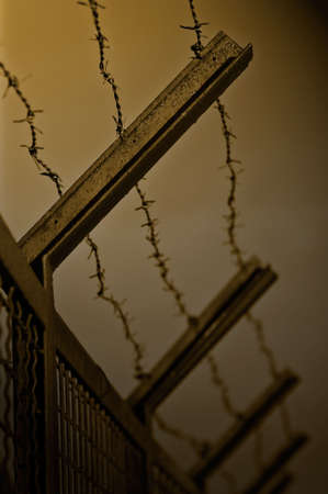 The security fence topped with barbed wire. Shallow DOF. Duotone.の写真素材