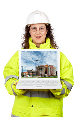 Female construction worker showing a building construction on the laptop.Note: on screen image was...