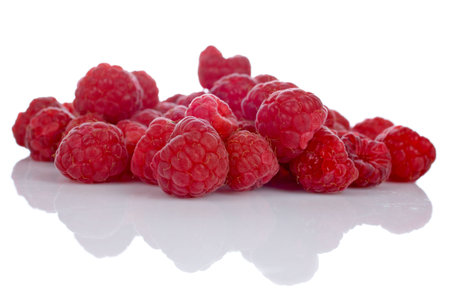A raspberries pile reflected on white background. Shallow DOF