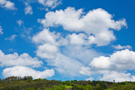 Mountain landscape, green filed, the blue sky and white cloudsの写真素材