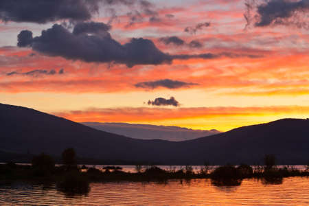 Colorful sunrise over the peaceful lake on springの写真素材
