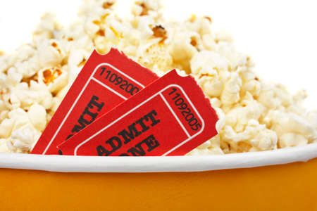Detail of popcorn in a bucket and two tickets over a white background. Tickets on focus and shallow DOFの写真素材