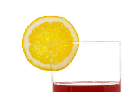 A glass of red juice with a lemon slice, reflected on white backgroundの写真素材