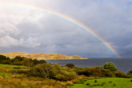 Rainbow above the lake with the cloudy sky, Isle of Skye, Scotlandの写真素材