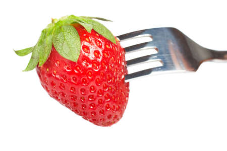 The fork pricking the strawberry isolated on white background. Shallow depth of fieldの写真素材
