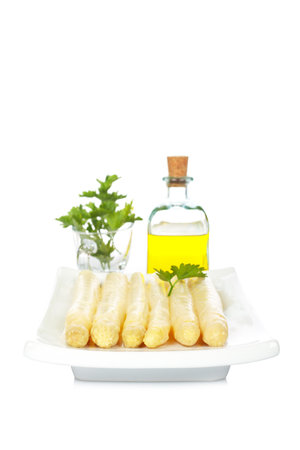 Asparagus in the white plate and extra virgin olive oil with parsley.  Soft shadow and shallow depth of fileの写真素材