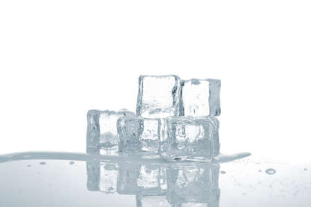 Melting ice cubes in water reflected on white background. Shallow depth of fieldの写真素材