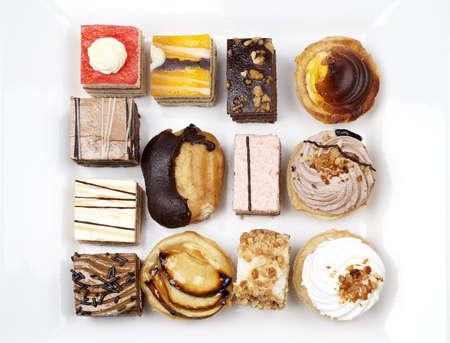 Assortment of delicious cakes with soft shadow on white plate. Shallow depth of fieldの写真素材
