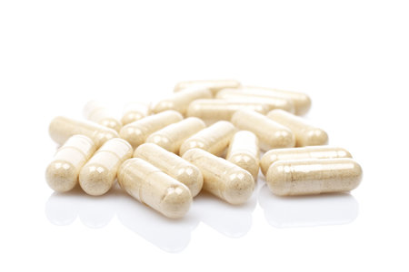 Capsules reflected on white background with shallow DOFの写真素材
