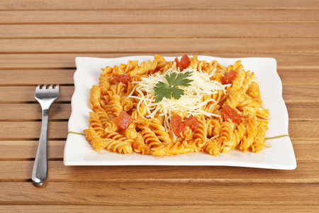Freshly cooked plate of fusilli pasta with tomato sauce just for eating. Shallow depth of fieldの写真素材