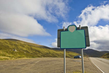 Blank billboard on blue sky in a mountainous area, just add your textの写真素材