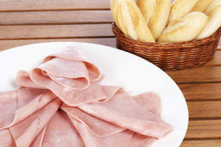 Slices of tasty ham on white dish and bread. Shallow depth of fieldの写真素材