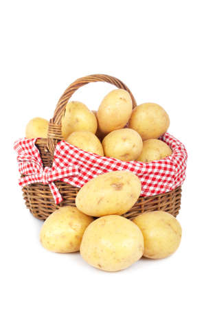Raw and fresh potatoes in the basket, isolated on white backgroundの写真素材
