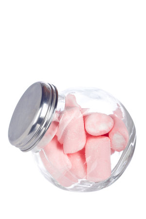 Pink marshmallows in the glass jar, isolated on white background