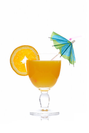 A glass of orange juice with a slice and umbrella, isolated on white background. Shallow depth of fieldの写真素材