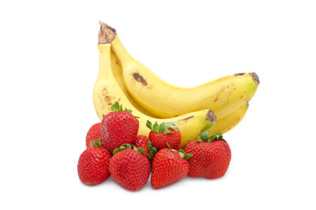 Bananas bunch and fresh strawberries with soft shadow on white background. Shallow depth of fieldの写真素材