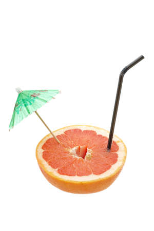 A fresh grapefruit with straw and umbrella isolated on white background. Shallow depth of fieldの写真素材