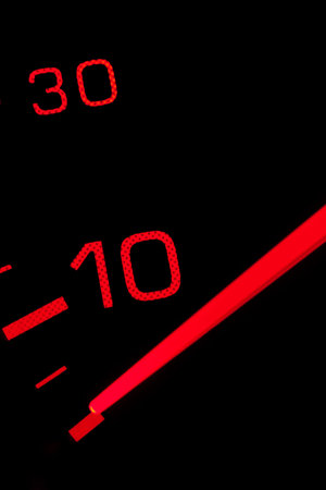 Orange neon speedometer over a black background