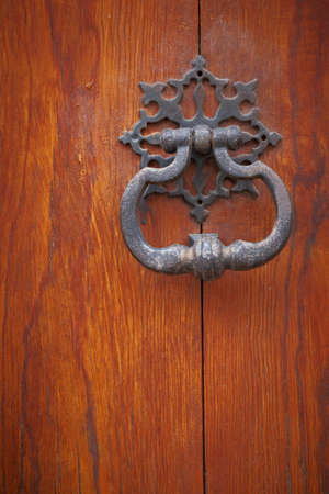 Old metal door handle knocker on wooden background
の写真素材