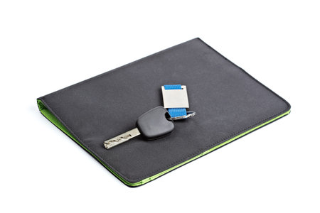 Car key and black folder isolated on white background with shallow depth of fieldの写真素材